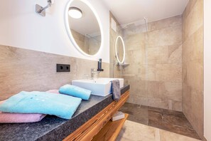 A modern bathroom with a vanity, a large mirror, and a shower area. - (7) Vacation rental on the 2nd floor with a balcony (Reit im Winkl)