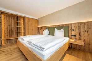 Ein Schlafzimmer mit einem Holzbettgestell, einem Kopfteil und einem Nachttisch mit Fernbedienung.