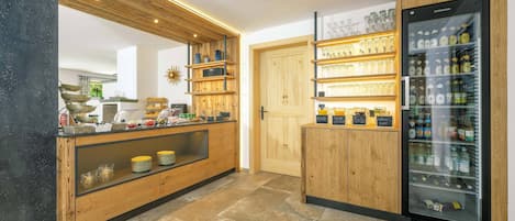 A modern kitchen with a wooden countertop, a built-in refrigerator, and a glass display case.
