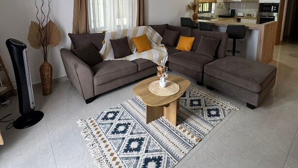 A living room with a sectional sofa, a coffee table, and a patterned rug. - Cdas&Fav Apartment Grand baie Mauritius  (Grand Baie)