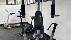 A gym with exercise equipment, a treadmill, and large windows. - Cdas&Fav Apartment Grand baie Mauritius  (Grand Baie)