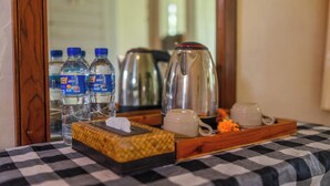 Ein karierter Tisch mit einer Tablett, auf dem Wasserflaschen, eine Kaffeekanne und eine Tasse stehen.