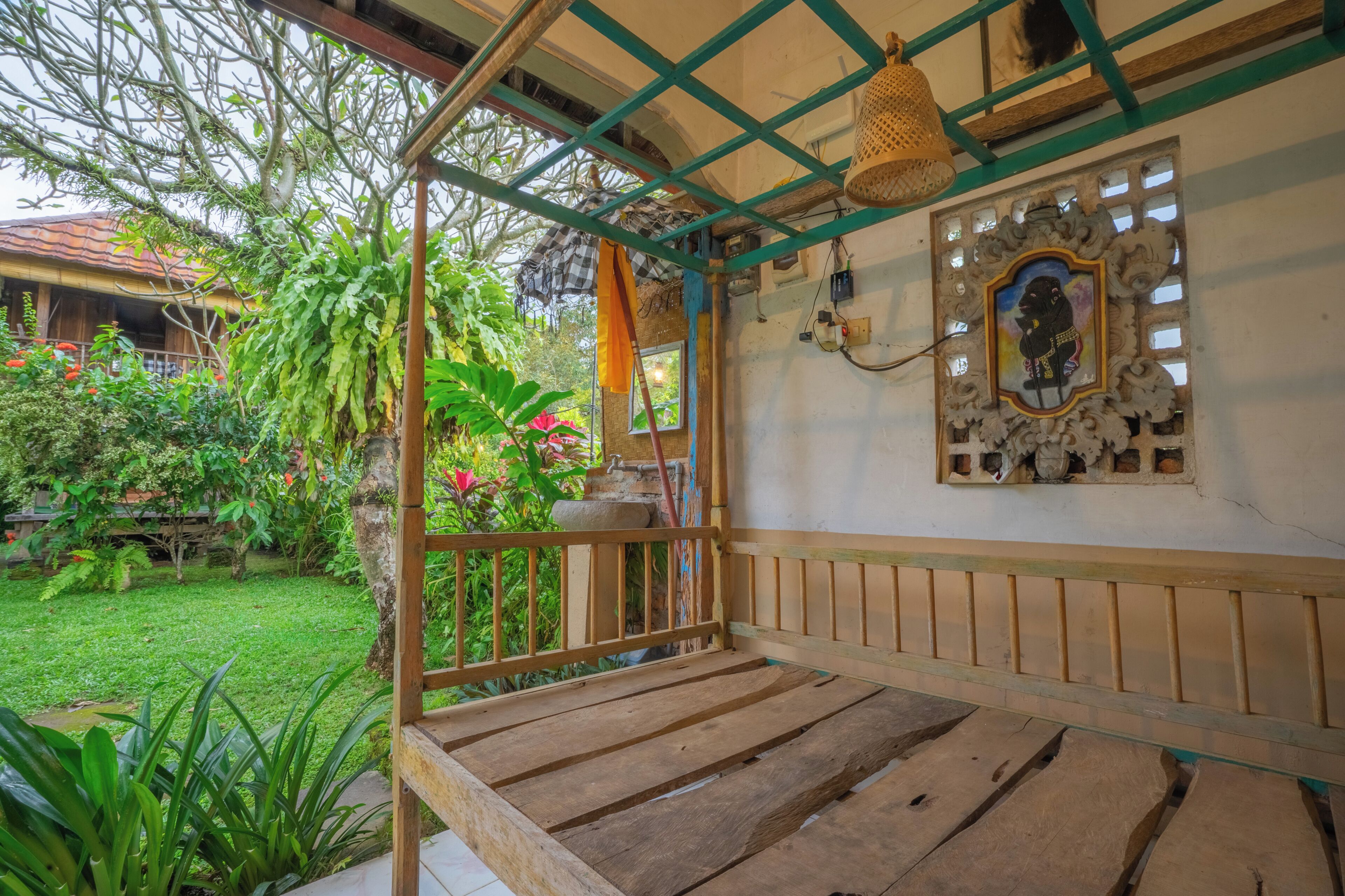 A wooden deck with a view of a garden and a house in the background.
