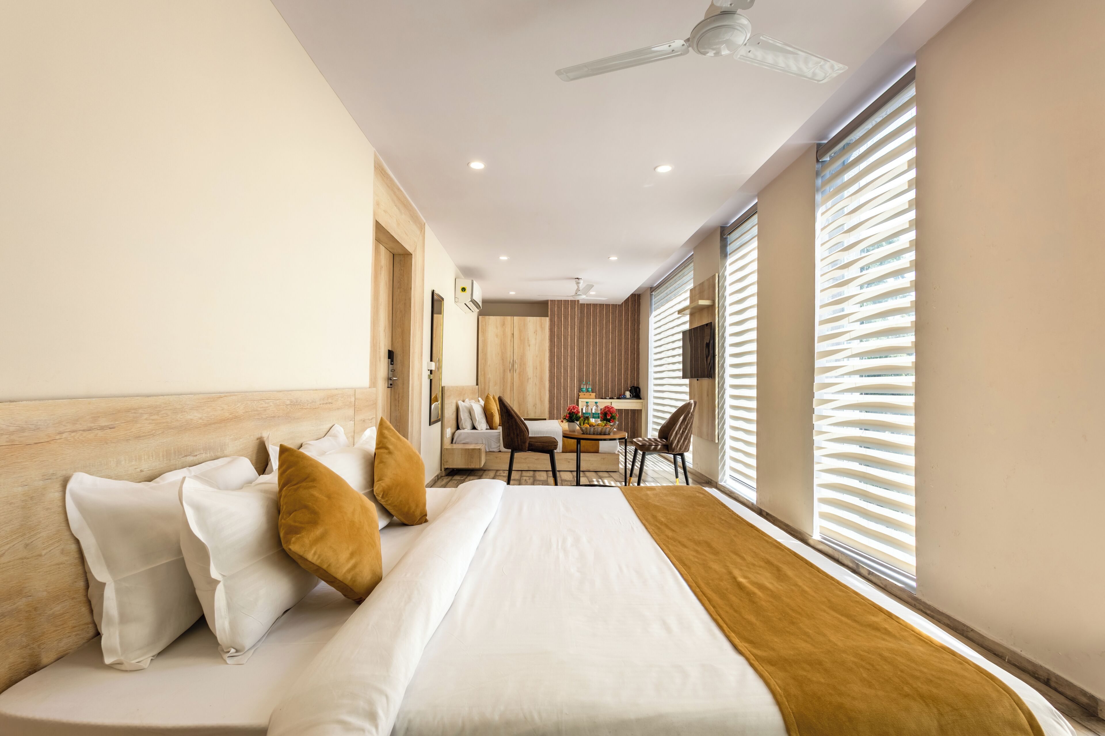 Una habitación de hotel moderna con cama, escritorio y zona de comedor.