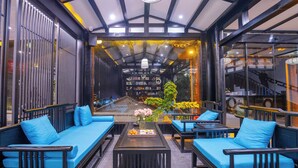A modern interior with a central seating area, a coffee table, and a view through a glass wall. - 12C View Homestay (Xiangxi)