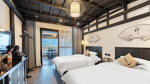 A hotel room with two beds, a wooden ceiling, a view of mountains, and a traditional fan on the wall. - 12C View Homestay (Xiangxi)