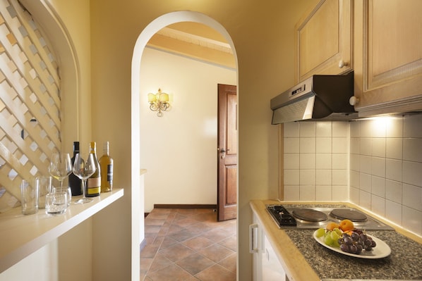 A kitchen with a countertop, a sink, and a door leading to another room. - Holiday Residence Il Giardino Degli Oleandri in Porto Cervo (Arzachena)