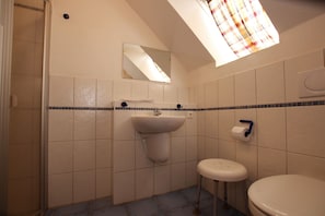 A bathroom with a sink, toilet, and a small stool. - Ferienhaus in Wernigerode mit Gemeinschaftspool (Wernigerode)