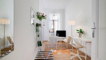 Een moderne, goed verlichte kamer met een bureau, stoel en televisie.