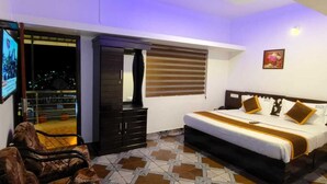Ein Schlafzimmer mit Bett, Kleiderschrank, Fernseher und Balkon.