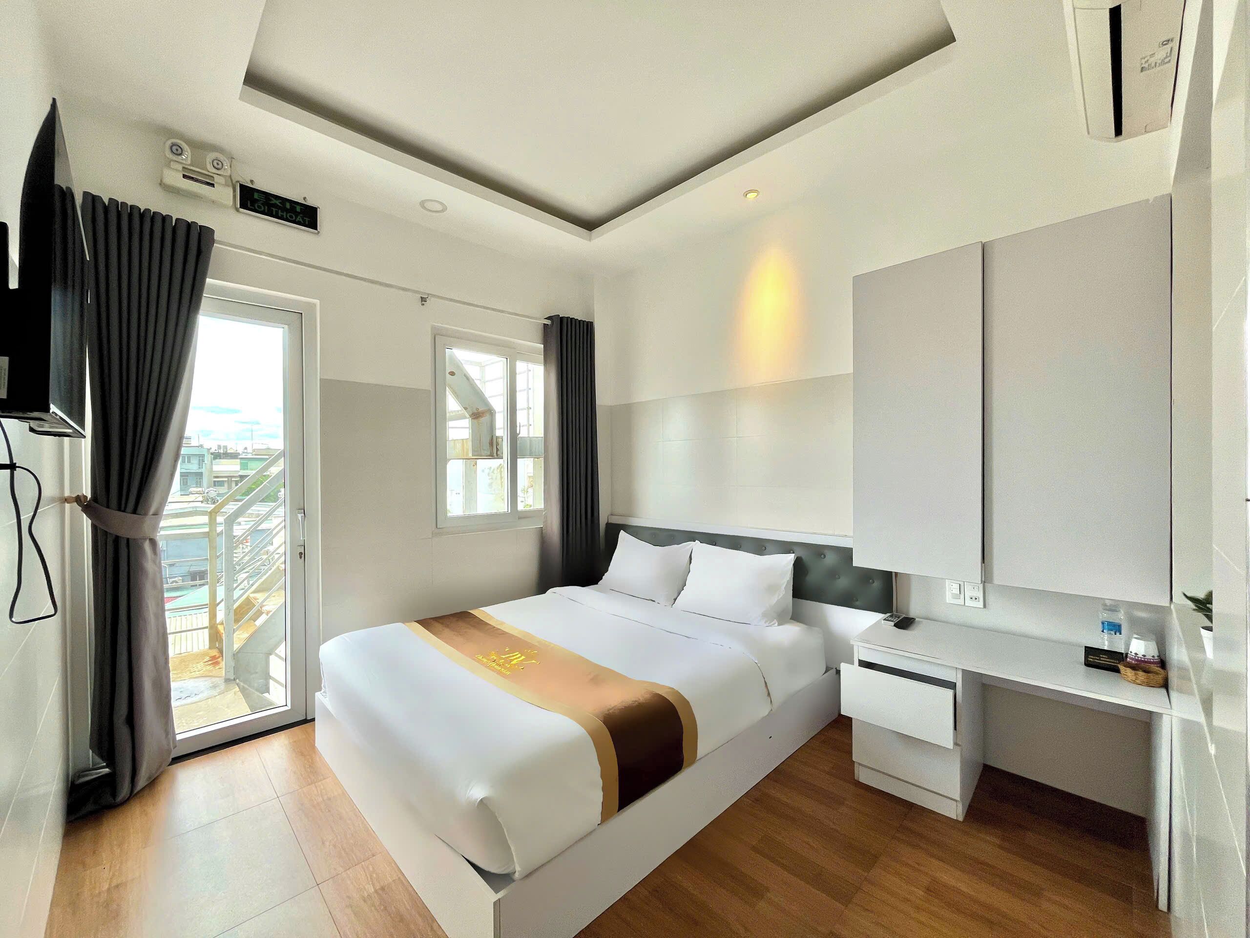 Et moderne hotelværelse med seng, skrivebord og udsigt over byen.