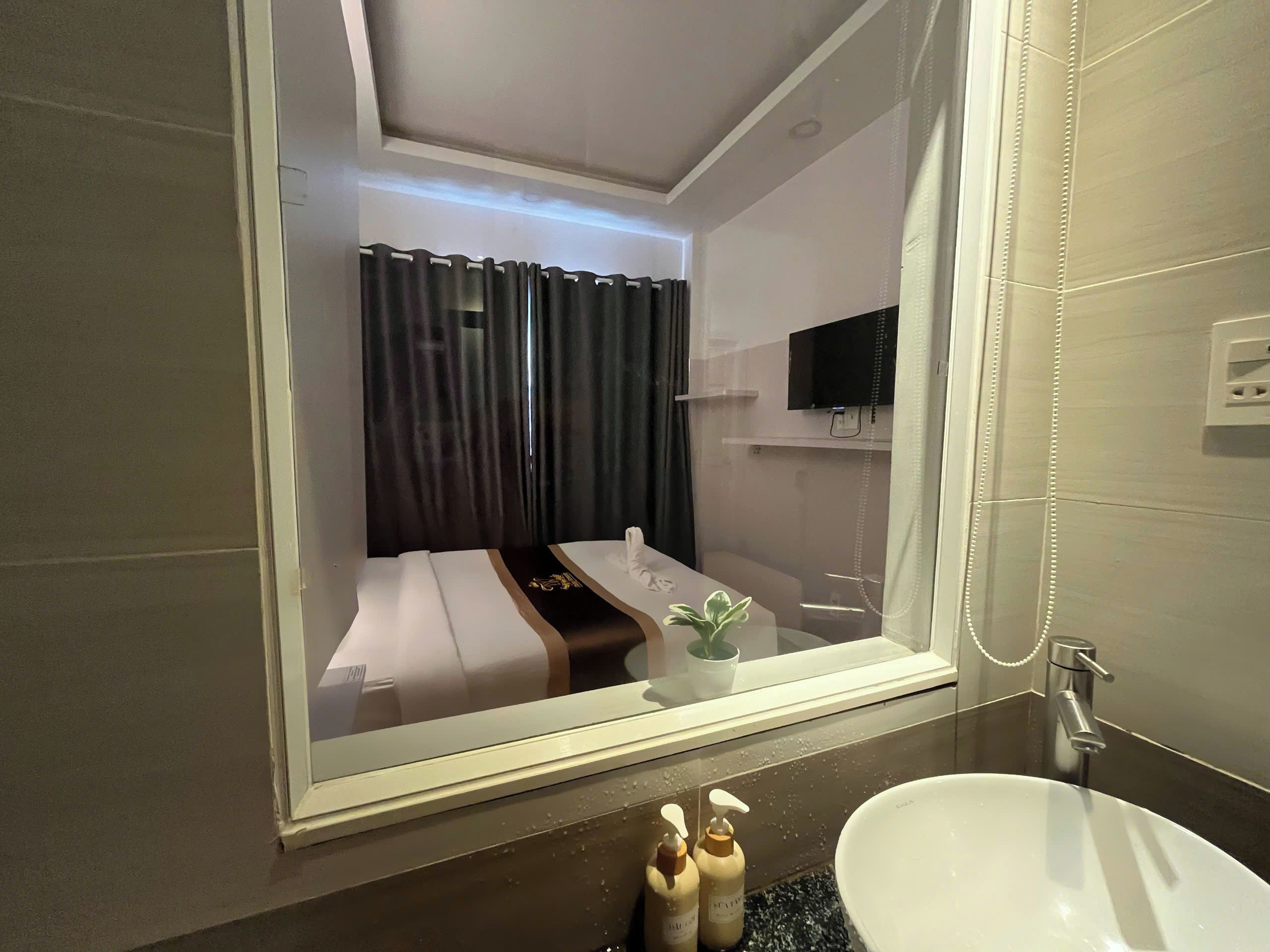 Ein modernes Badezimmer mit einem großen Spiegel, einem Waschbecken und einer Dusche.