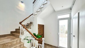 Un escalier avec des rampes blanches et des marches en bois menant à un palier.