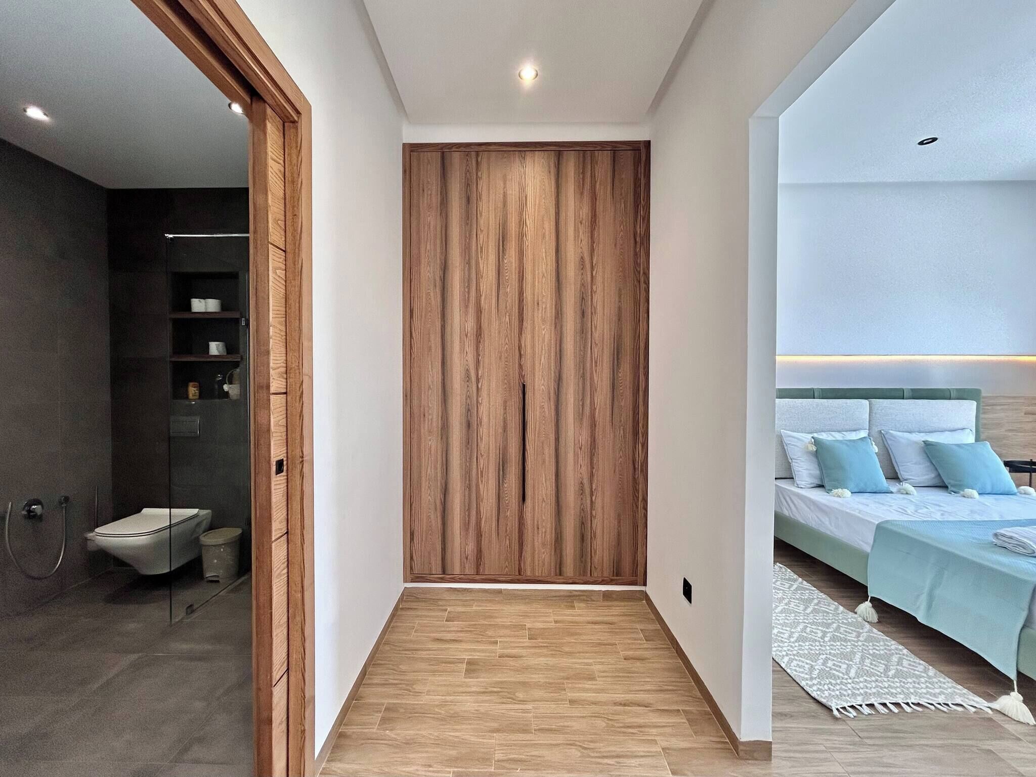 A modern bedroom with a bed, bedside tables, and a wardrobe.