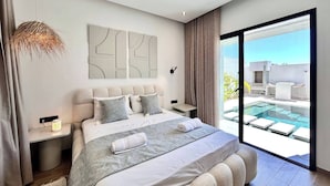 Un dormitorio moderno con una cama grande, una mesita de noche, una lámpara de pared y vistas a una piscina exterior.