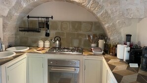 A kitchen with a stone arch, two sinks, a stove, and a built-in oven. - Olivi estate with private pool in Ceglie 2 and 4/6/8 pax (Ceglie Messapica)
