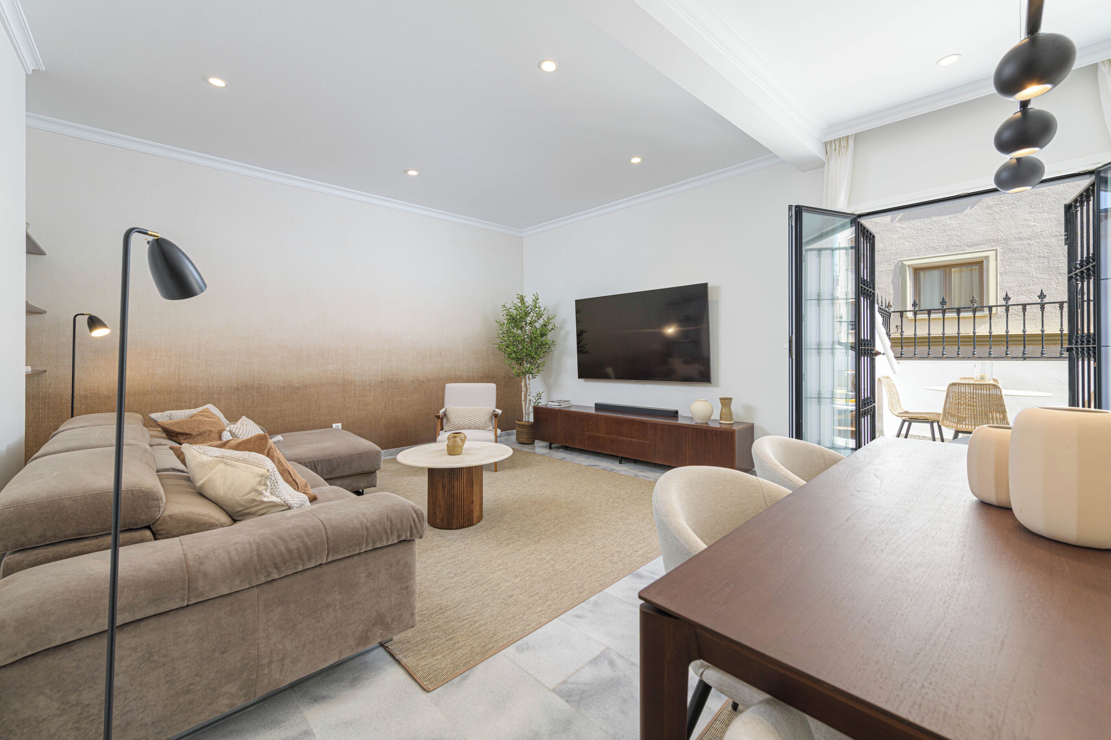 Una sala de estar moderna con un sofá, una mesa de centro y un televisor.