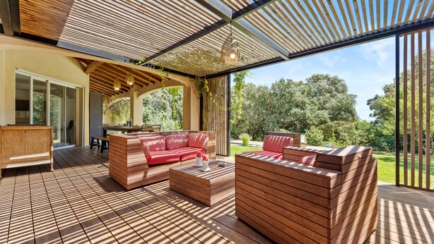 An outdoor living area with wooden furniture, a pergola, and a view of the surrounding greenery. - Bed and Breakfast 'Nimes' with Shared Pool, Shared Terrace and Wi-Fi (Nîmes)