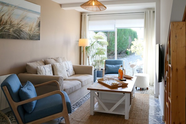 A living room with a sofa, armchair, coffee table, and a TV. - Cancal'ou (Cancale)