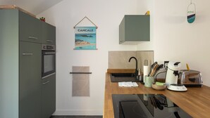 Uma cozinha moderna com forno embutido, micro-ondas e máquina de café no balcão.