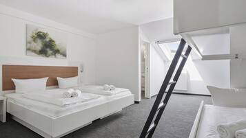 Una camera d'albergo moderna con un letto grande, una testiera, un quadro al muro e un lucernario.