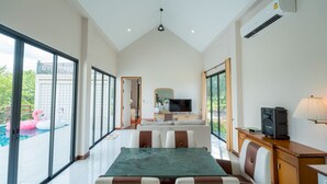 Amplia sala de estar con mesa de comedor, sofá y televisor.