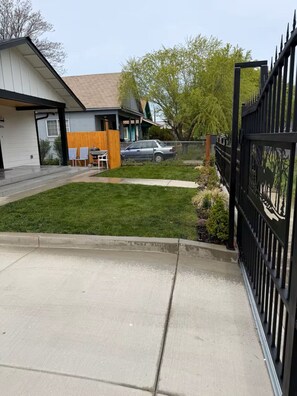 A residential property with a paved driveway, a fenced yard, and a garage. - A peaceful place (Yakima)