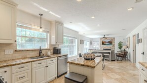 A spacious kitchen with white cabinets, granite countertops, and a central island. - Resort-Style Pool + Spa + BBQ. Spacious 4 bdr Home @The Woodlands (Spring)