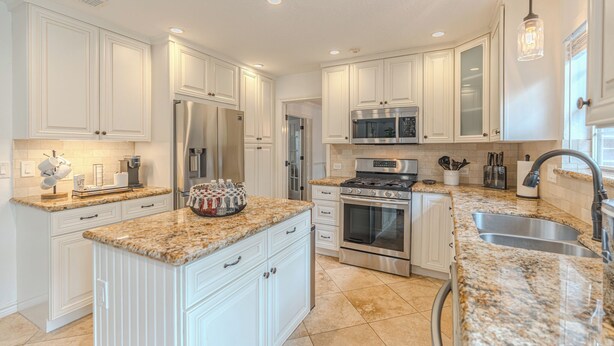 A modern kitchen with white cabinetry, granite countertops, stainless steel appliances, and a large island. - Resort-Style Pool + Spa + BBQ. Spacious 4 bdr Home @The Woodlands (Spring)