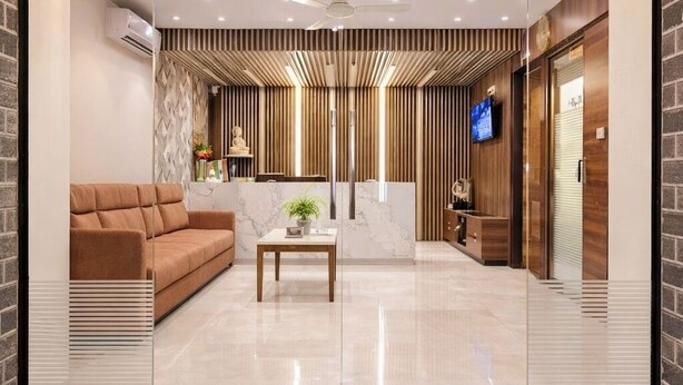 Um hall moderno com um sofá, uma mesa de centro, uma televisão e um balcão de recepção.