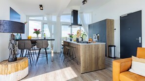 Eine moderne Küche mit einer Holztheke, Barhocker und Blick auf die Stadt.