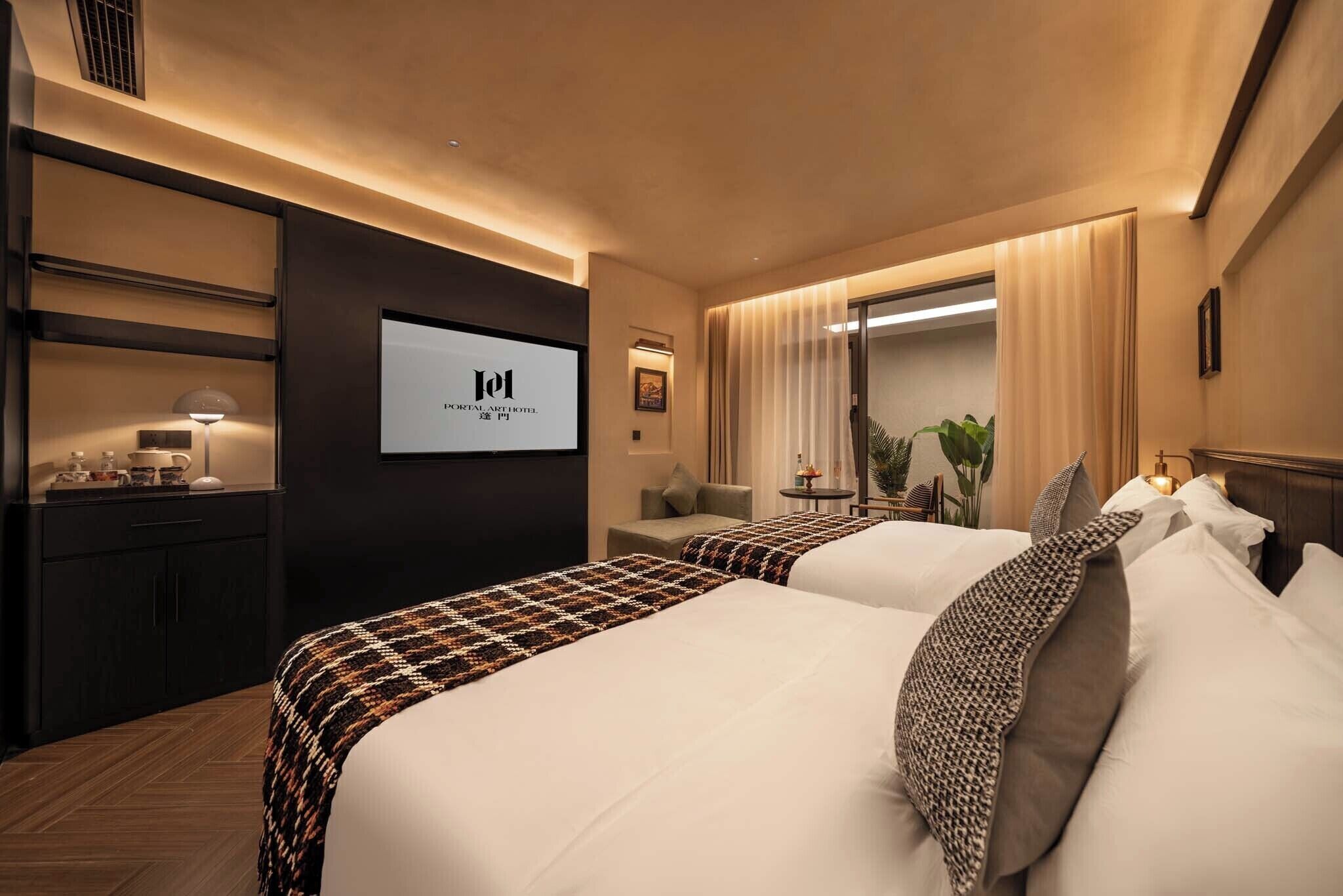 A hotel room with two beds, a desk, a TV, and a window with curtains.