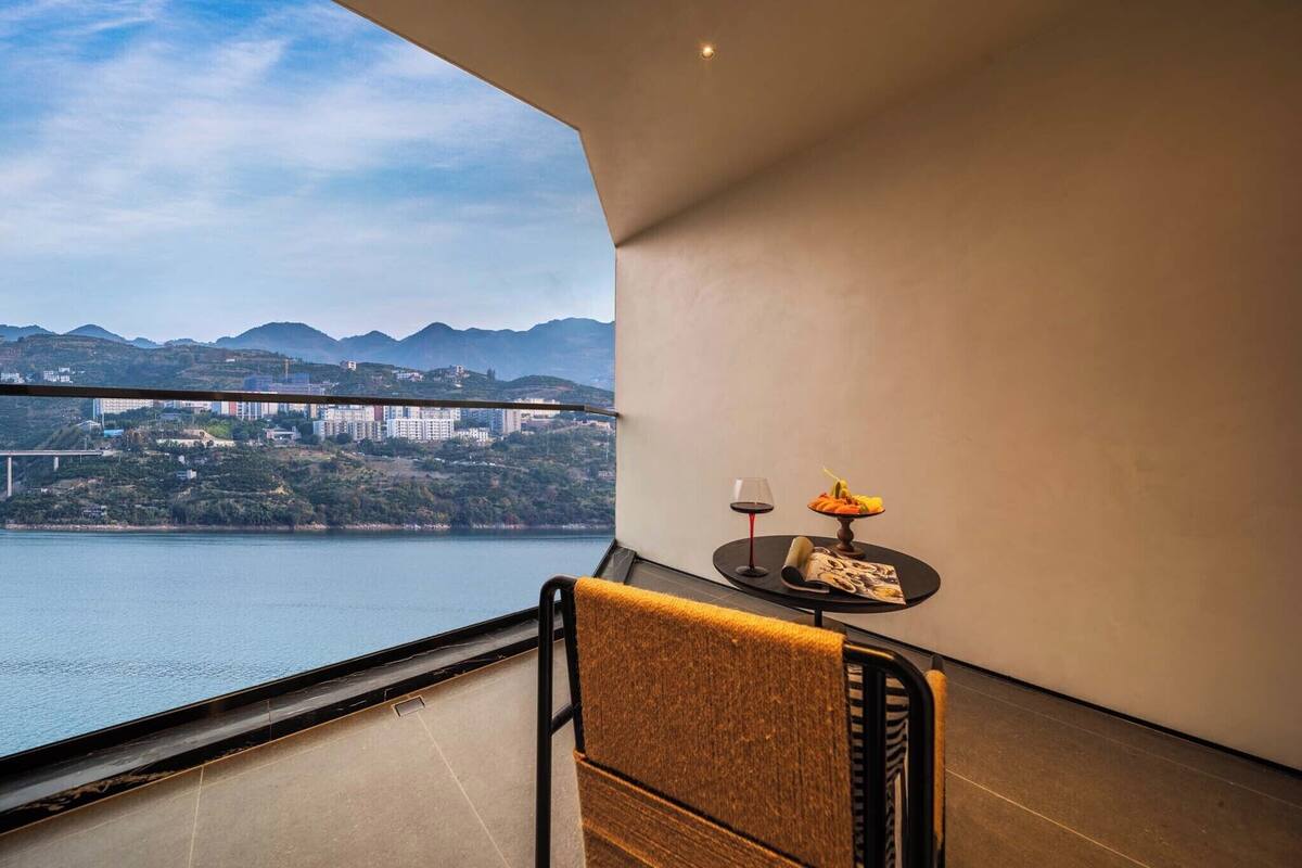 Un balcon offrant une vue sur un pont, des montagnes et une étendue d’eau.