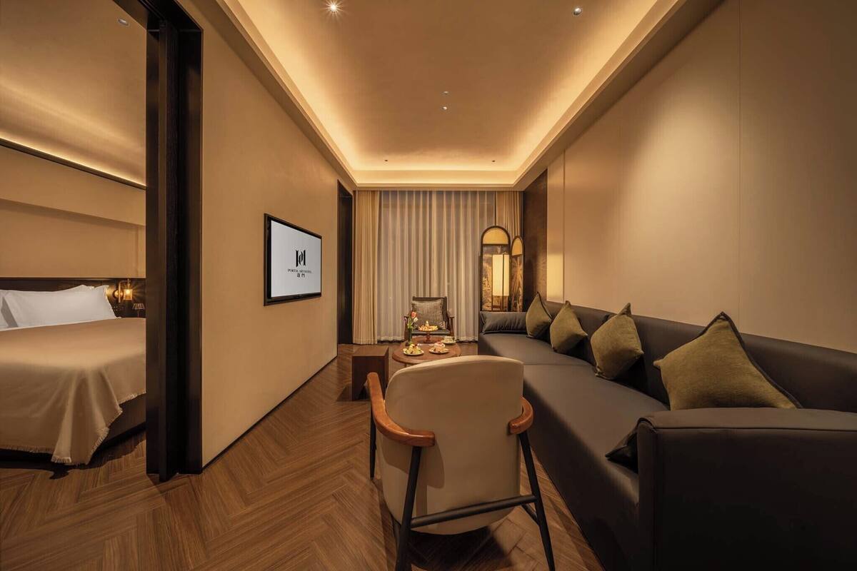 Une chambre d’hôtel comprenant un lit, un canapé, une chaise, une télévision et une table à manger.