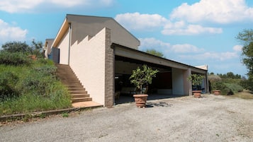 A modern building with a garage, a staircase, and potted plants.