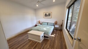 A bedroom with a bed, bedside tables, a window, and a ceiling fan. - Where Paris meets Jupiter - Linen, Wi-Fi, Pets OK (Venus Bay)