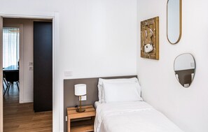 A bedroom with a bed, bedside lamp, wall-mounted mirror, and a painting. - Art&Fashion- Ariom Apartments (Moniga del Garda)