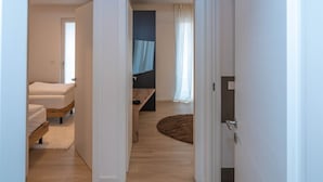 Ein modernes Zimmer mit einem Bett, einem Schreibtisch und einem fenster mit Vorhängen.