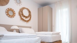 Une chambre d’hôtel avec deux lits, une armoire et des œuvres d’art décoratives au mur.