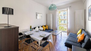 A modern living space with a dining area, sofa, and balcony. - Warm Apartment 2P in the heart of Nice - near the sea (Nice)
