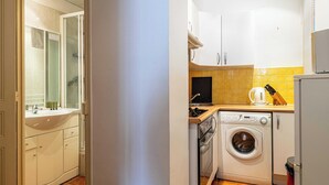 A compact kitchen with a washing machine, a sink, and cabinets. - Warm Apartment 2P in the heart of Nice - near the sea (Nice)