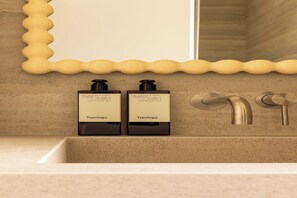A bathroom with a mirror, two bottles of Typology body wash, and a modern faucet. - Modern Apartment a/c 1CH/4P - Saint -Germain (Paris)