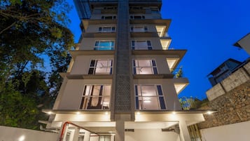 A multi-story building with a central atrium, balconies, and a staircase.