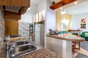 A kitchen with a granite countertop, stainless steel sink, and a built-in oven. - Holiday Home 'Da Minnanna' with Private Garden, Wi-Fi and Air Conditioning (Badesi)
