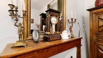 Un aparador de madera con un reloj, un candelabro y un florero.