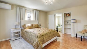 A bedroom with a bed, a nightstand, a lamp, a chair, a shelf with a decorative item, and a door leading to another room. - 1 Mi to NYC Train & Arts District: Rahway Escape (Rahway)