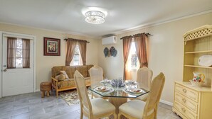 A dining area with a glass table, wicker chairs, a sofa, and a decorative cabinet. - 1 Mi to NYC Train & Arts District: Rahway Escape (Rahway)