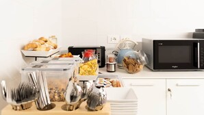 A kitchen with a microwave, toaster, and various food containers. - Flamingo affittacamere - Camera 4 (Matera)