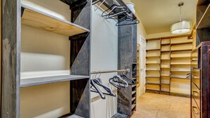 A walk-in closet with open shelves, a clothing rack, and a hanging light fixture. - Family + Pet Friendly: Fort Worth Home Near TCU! (Fort Worth)