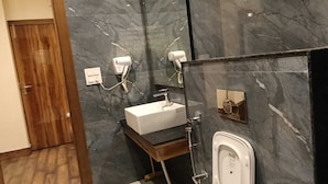 A bathroom with a marble wall, a wooden door, a white sink, and a shower. - Kufri Paradise Villa By Mountain Bee (Theog)